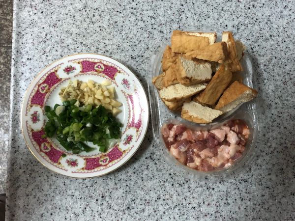 將油豆腐對切，青蔥切蔥花，薑片切末，蒜頭切末，豬絞肉與醃料混合均勻