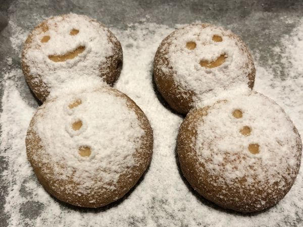 取出烤好的餅乾，放涼，在餅乾上方篩滿糖粉。

準備好牙籤，開始來畫臉囉！