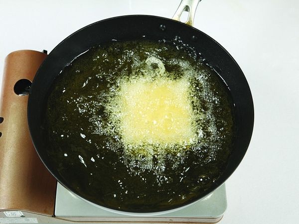 在深鍋內加入食用油加熱油後，放入豆腐並以大火油炸。(油量要到豆腐高度的一半)