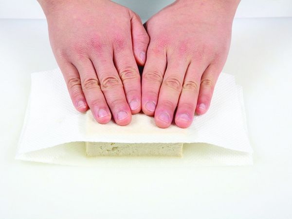 凍豆腐整塊泡水解凍後，輕輕按壓上下將水分擠出。