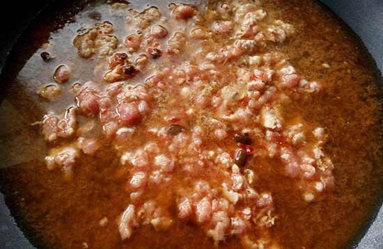 絞肉炒至半熟，再加入豆瓣醬及醬油炒香後，倒入水煮至滾