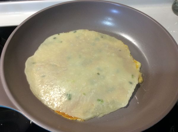 倒入1/2的蛋液，在蓋上一片蛋餅皮。