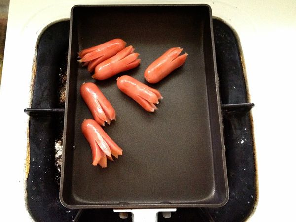 鍋子沾點油，熱鍋。德式起司腸下鍋，不時在鍋裡滾動，讓起司腸外圍均勻受熱，小章魚的腳就會均勻地Q起來。