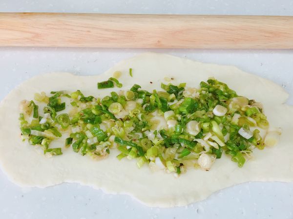 將鬆弛好的小麵團桿平
擀麵棍上可以抹油比較好推開
抹上蔥花均勻分布