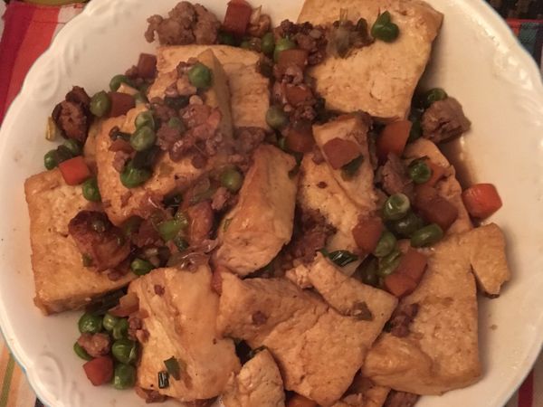 薑小火麻油爆香後加入肉末炒熟、加青紅豆、加豆腐、米酒、醬油中火煮10分鐘、最後加蔥粒翻炒一會起鍋食用.