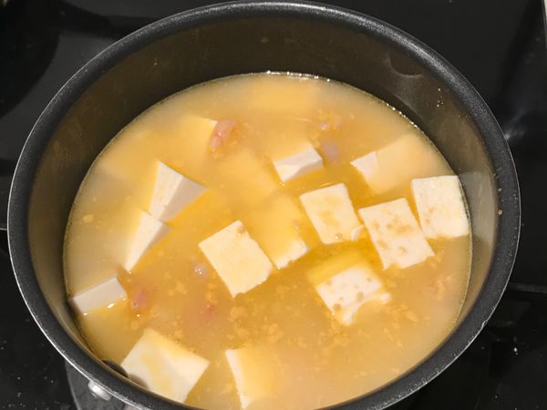 加入半碗雞高湯或水，豆腐塊加入煮六分鐘（讓水量剛剛好淹過所有食材）