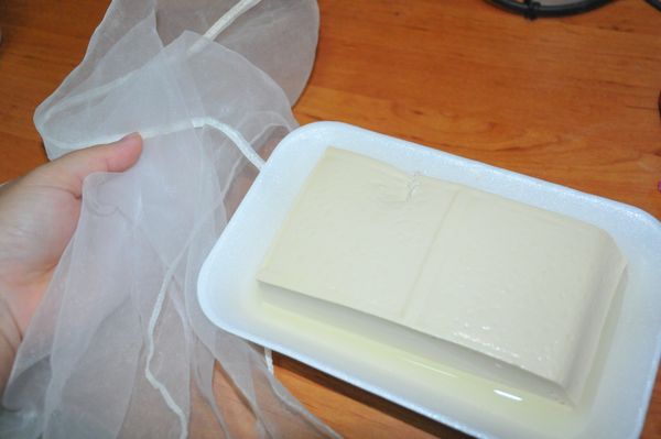 因為豆腐仍有水份，要先用紗布把水擰出。