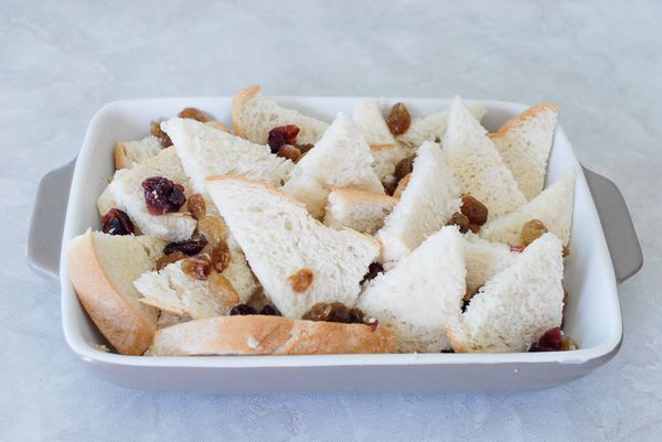 用少許奶油塗抹烤盤，然後將麵包排好，再灑上葡萄乾