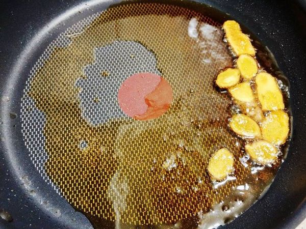 鍋中倒入麻油，放入薑片，小火慢煸