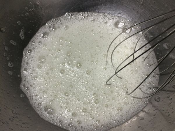將蛋白用電動打蛋器打發出現粗泡沫狀，加入砂糖。（分三次加入）