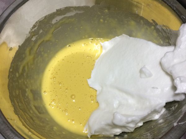將1/3的蛋白霜加入蛋黃糊之中用刮刀拌勻。