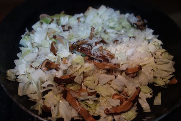 米洗乾淨, 高麗菜切小塊, 乾香菇泡開切絲, 乾干貝泡開撕成絲, 蒜頭切末。在炒鍋內放一點點油, 用中火爆香蒜末, 再把香菇跟干貝放入炒香, 最後放入高麗菜跟米一起拌炒約5~8分鐘後裝到大同電鍋的內鍋裡。