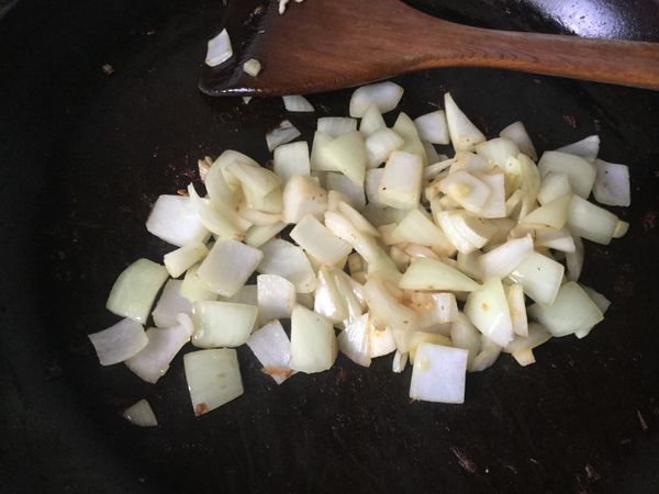 同一炒鍋加入大蒜和洋蔥拌炒，炒至洋蔥稍微變黃。