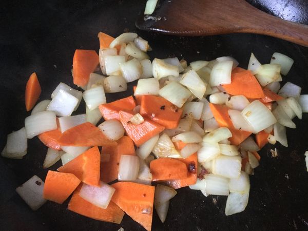 炒鍋中續加入紅蘿蔔拌炒，炒至紅蘿蔔稍微變軟。