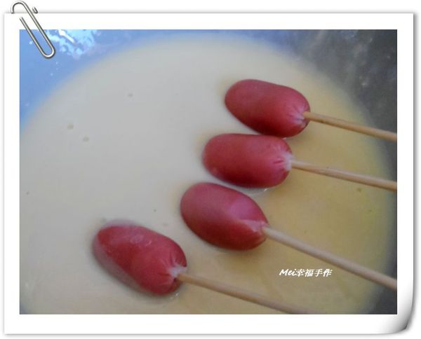 鑫鑫腸用竹籤插好，再放入鬆餅粉麵糊裡