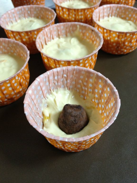 攪拌均勻,再將麵糊放入紙杯 中間放入巧克力 
  再倒入麵糊蓋住約至杯子6-7分滿