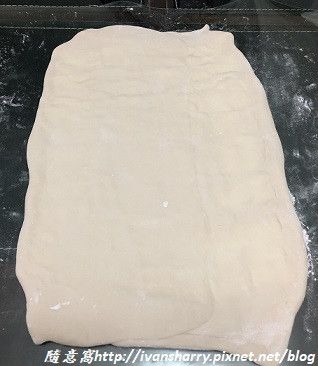 用擀麵棍將包好奶油的麵皮擀平成長方形大薄片