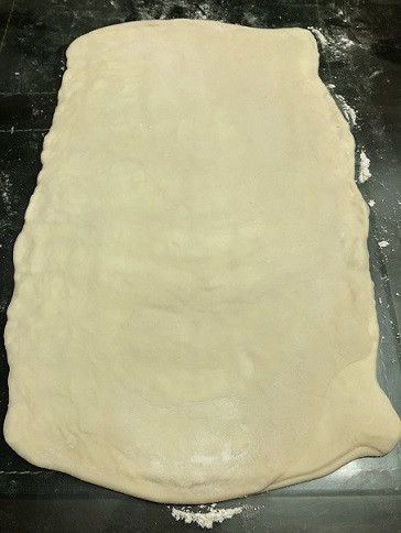 用擀麵棍將麵糰擀開、擀成長方形大薄片