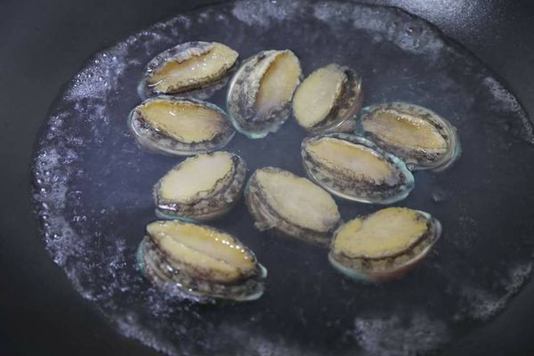 取一滾水將鮑魚整顆放入煮約30秒後熄火悶一分鐘取出泡在冷開水裡備用