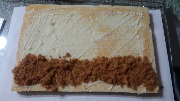 鋪上白報紙翻面在麵包前端用刀子劃幾刀(不切斷),抹上沙拉醬,前端鋪上肉鬆