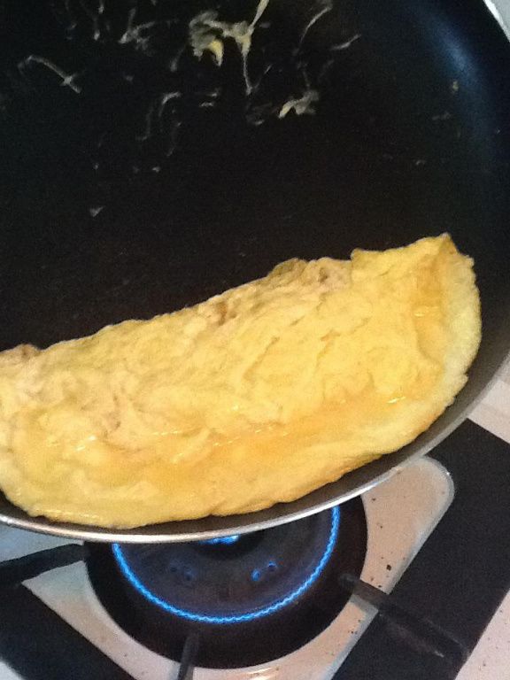 大約至 4~5 分熟的時候(約10~15秒左右), 轉小火, 開始把蛋往角落推, 然後翻一面讓蛋皮剛好合起來