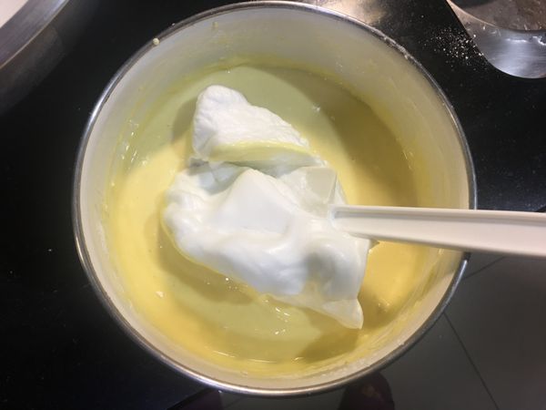 取1/4蛋白霜到蛋黃糊裡，用刮刀輕劃融合，再全部倒回到蛋白霜的大碗中，兩者完全相融，勿用力攪拌避免消泡
