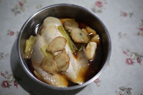 把豆腐鋪底, 放上浸泡好的虱目魚肚, 撒上蔥段跟薑片, 淋上所有的調味料。 放入電鍋裡蒸, 外鍋放一杯水。