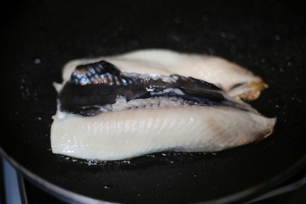 在平底鍋裡, 放一大匙油熱鍋後, 魚皮朝下煎。等到魚肉泛白之後才可以翻面, 之後根據個人喜好來調整煎的程度（像我喜歡吃赤赤的皮, 就可以多煎幾下魚皮）