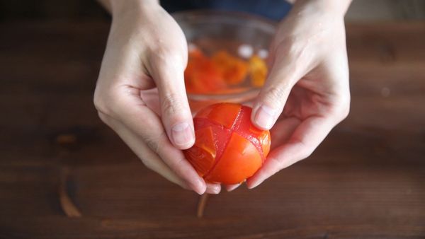 首先將番茄外皮畫上十字後，用滾水稍微燙過，接著撈起泡入冰水中，這樣就可以輕易的將番茄皮去除了。