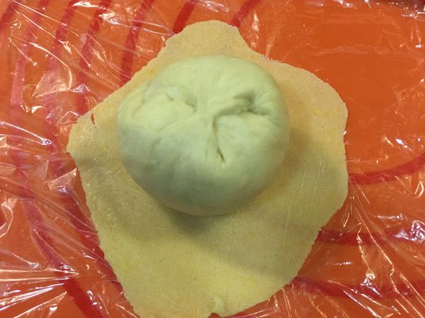 打開上層保鮮膜，將麵糰正面朝下包進酥皮