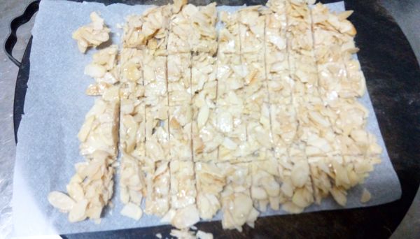 放入模型壓平均，趁熱按照糖果袋切長度，裝入袋內。