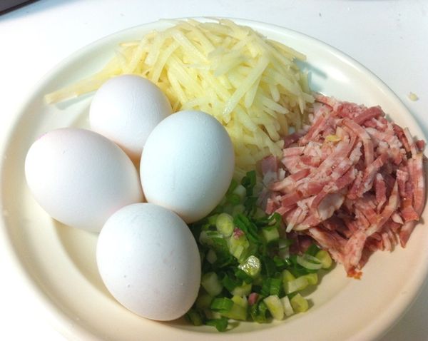 將馬鈴薯刨成粗絲，培根切成細絲備用。