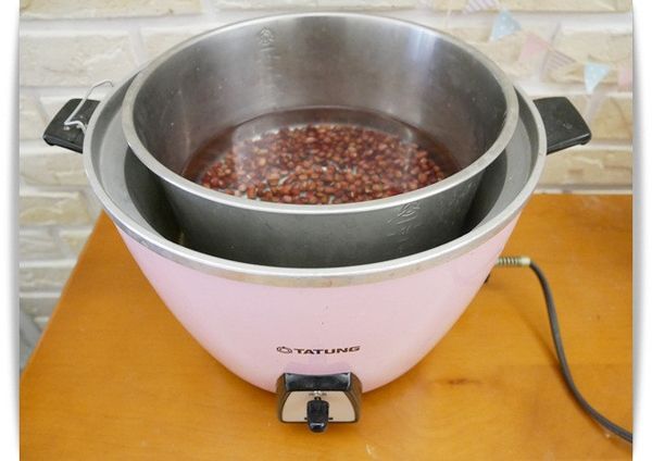 接著再將浸泡後的紅豆用水清洗乾淨，放入電鍋內鍋並且倒入適量的水後外鍋放兩杯水，跳起後在外鍋再倒入兩杯水續煮至跳起並且紅豆呈現熟軟狀態即完成。(寶寶版不需加糖，若是大人食用待煮熟軟後再加糖調味。)