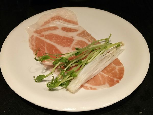 將豬肉片攤開，放上適量蔬菜。