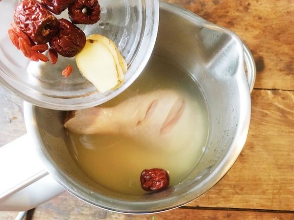 鍋中放入作法1的白米和棒棒雞腿、薑片、紅棗、枸杞。