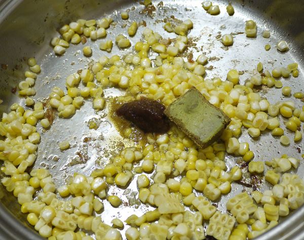 步驟2漿玉米粒下鍋用剩餘的油炒熟,加沙茶及穀盛綠咖哩塊,加100CC的水一起煮到穀盛綠咖哩融掉