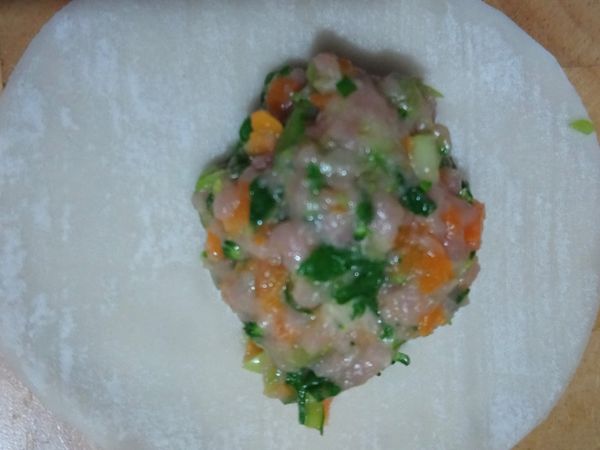 將一茶匙餡放入餃子皮，用水封邊造型