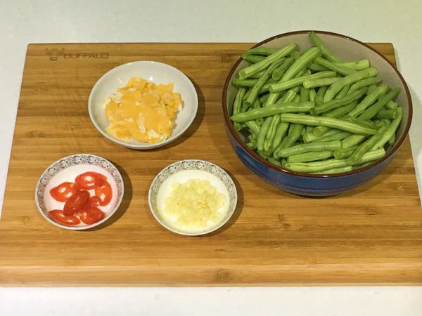 將四季豆去頭尾切對半；蒜頭去膜切末；辣椒切斜片；鹹蛋將蛋黃及蛋白分開，蛋黃搗碎備用。（蛋白視鹹度切末適量加入）