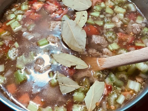 後加入水約蓋過食材後一個指節深，加入月桂葉後，蓋蓋子轉中火燉煮45分鐘