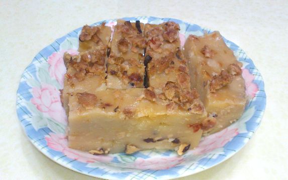 將在來米漿分次倒入鍋中，以小火拌攪至成糊狀熄火，盛入大型磁碗中，抹平後上層鋪上少許油蔥與芋頭，放入蒸鍋中以大火蒸30分鐘即可。