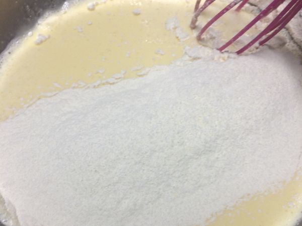 將麵粉分兩次過篩加入拌勻。