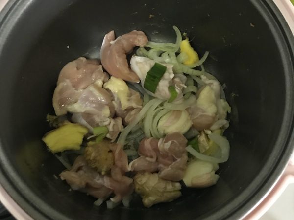 電子鍋內鍋擦乾，加入少許油，蒜頭、薑、洋蔥下鍋，蓋起來（按下炊飯鈕）約3-5分鐘爆香；
開鍋後加入雞肉和2匙醬油，再次蓋鍋燜炒
（雞肉跟辛香料共炒可去腥）