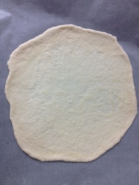 在烘焙紙上壓扁，擀平直徑約25cm，(以免移動拉扯後回縮)