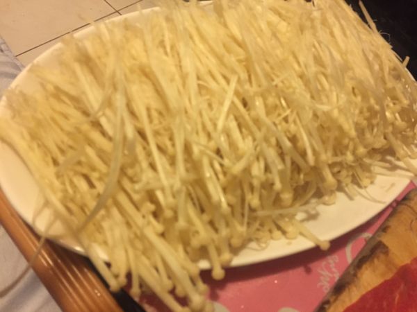 把金針菇尾部不能食用的地方切掉,剩下的將其分散(這樣捲好之後的肉捲口感較好咀嚼)