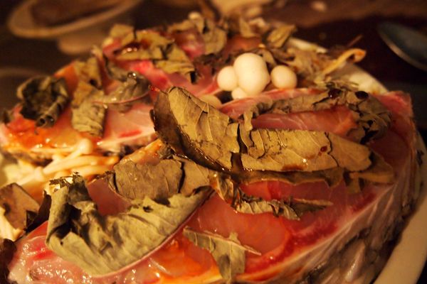 高麗菜絲與袖珍菇鋪平於淺盤上，將鮸魚放上，並將刺蔥一片一片的蓋滿魚肉，有多的放在旁邊的蔬菜上。