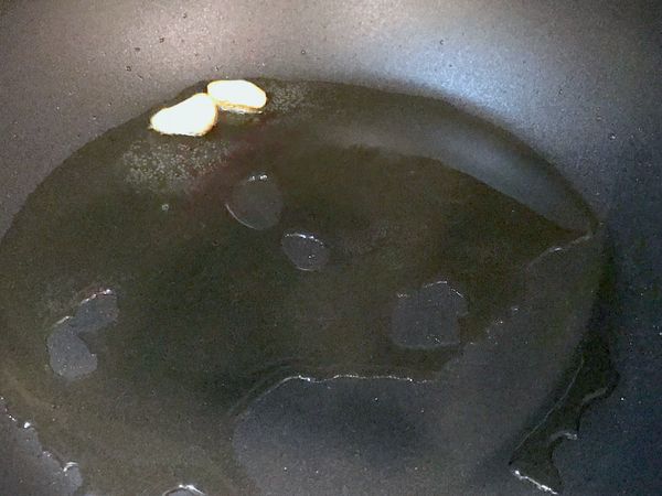 鍋中加入2大匙油中小火燒熱，將蒜頭(磨泥剩下的)加入炒出香味，然後取出放入雞肉。