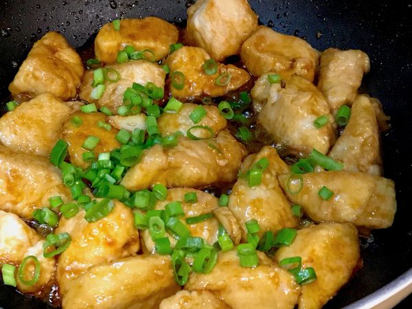 翻動雞肉讓醬汁均勻裹附，醬汁變濃稠後加入蔥花，大略拌一下即可關火盛盤。