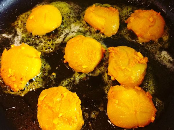 將醃了薑黃泥的干貝在鍋中每面煎約30秒，至表面略焦黃，中間微透即起鍋