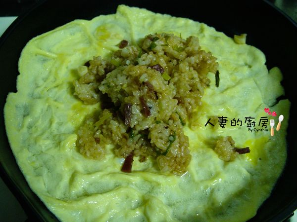 等蛋八分熟後將飯加到蛋皮上面，接著小心的將蛋用捲的方式捲起（用盤子來幫忙很方便）