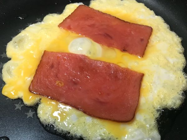 同樣的鍋子裡，倒入些許的油加熱後，
將適量的蛋液倒入，並擺上配料食材。